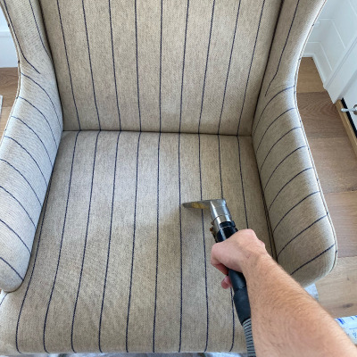using a cleaning wand tool to clean a dirty chair